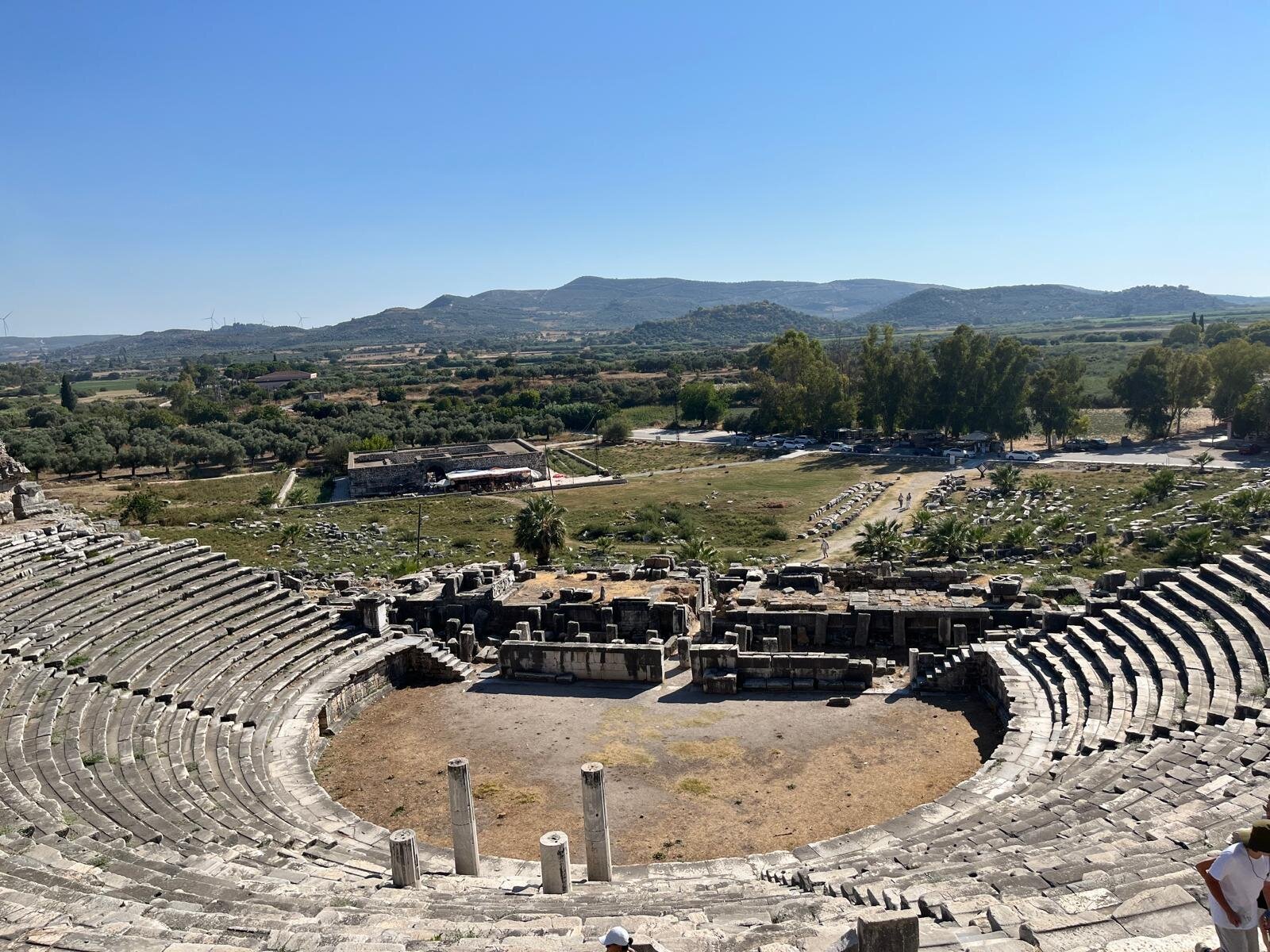 The ancient theatre of Miletus seen from the upper seating rows, with the plain and distant hills beyond.